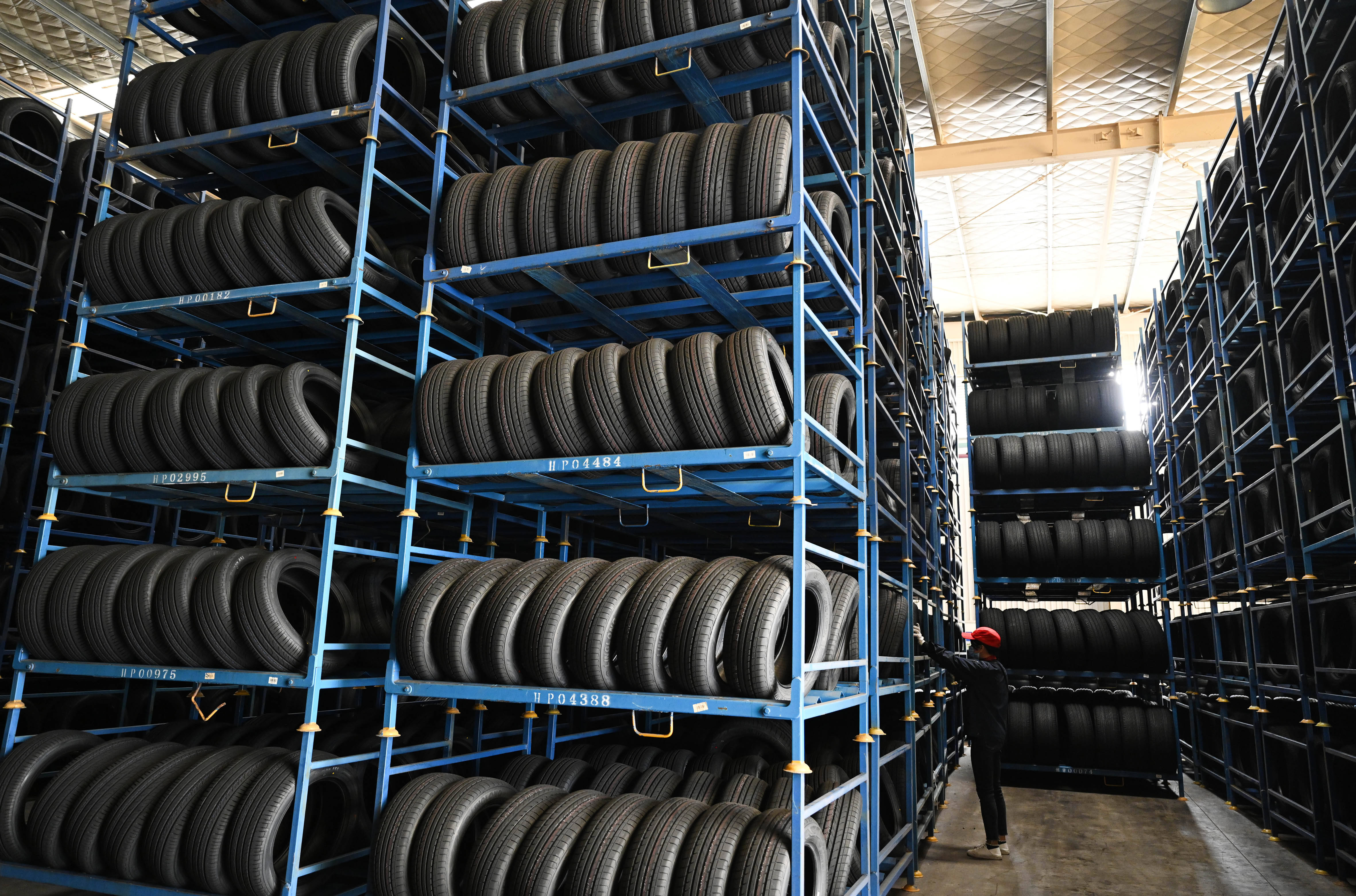2月22日,在广西柳州一家汽车轮胎企业,工人在仓库里对即将出仓的轮胎